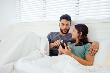 Happy, phone and couple in bed in morning for social...