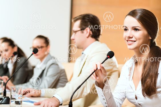 Business woman speaks into a microphone