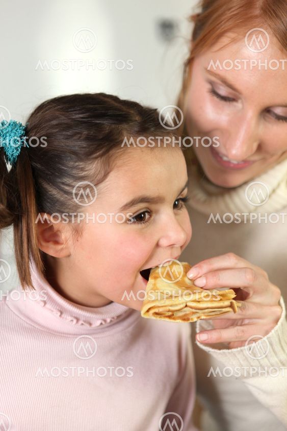 Mother and daughter eating pancakes