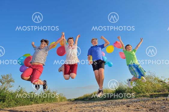 happy children jumping on field with balloons