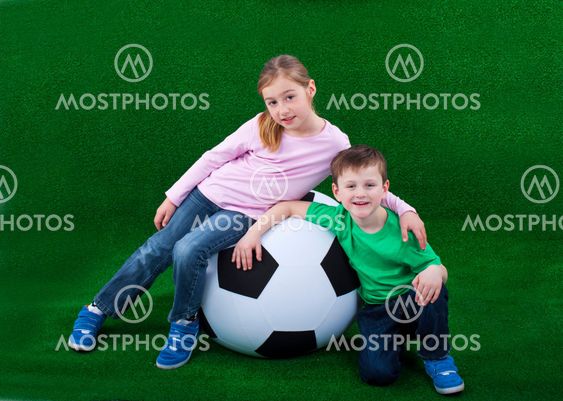 Two kids on a big foot ball