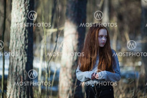 thirteen-year-old skinny girl in a summer pine forest.