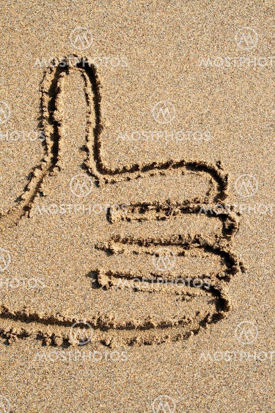 A thumbs-up sign drawn on the beach.