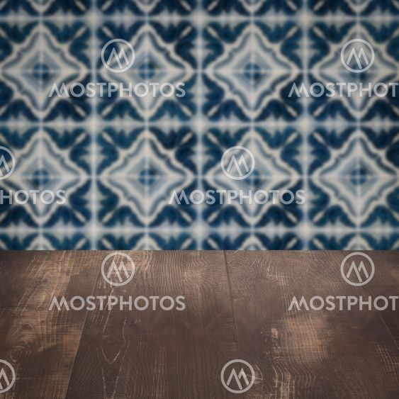 Wood table top and blur vintage ceramic tile pattern wall
