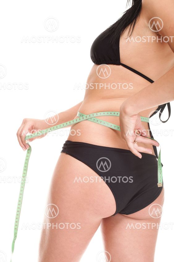 Girl measuring, perfect shape of beautiful thigh. Studio