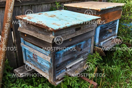 Old empty beehives in the garden near the fence