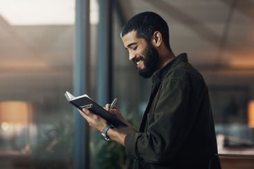 Writing, smile and notebook with business man in office...