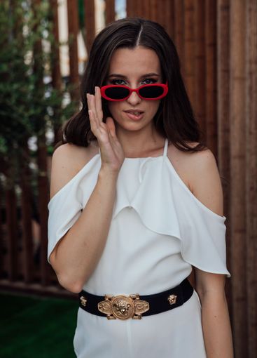 Beautiful fashionable brunette woman in white suit by...