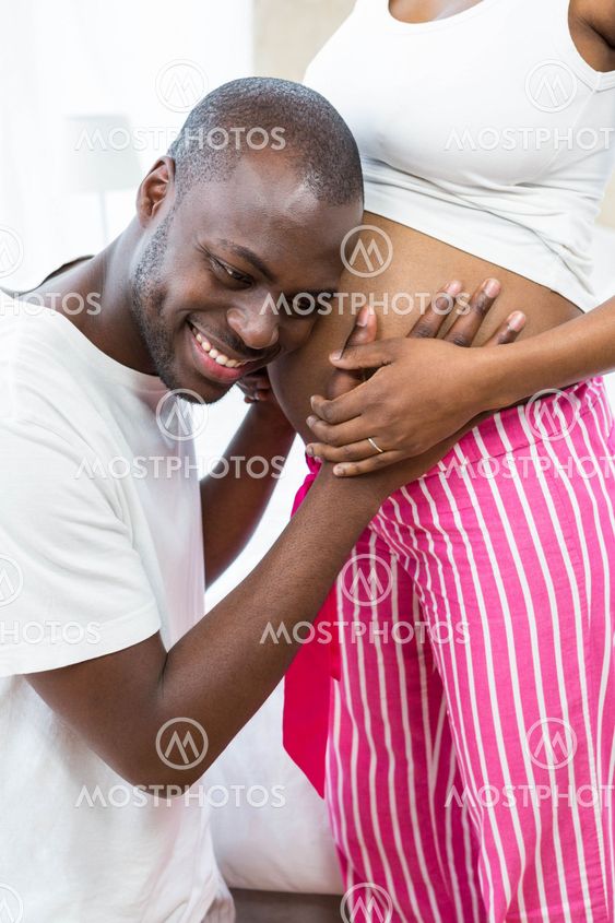 Man listening to pregnant womans stomach