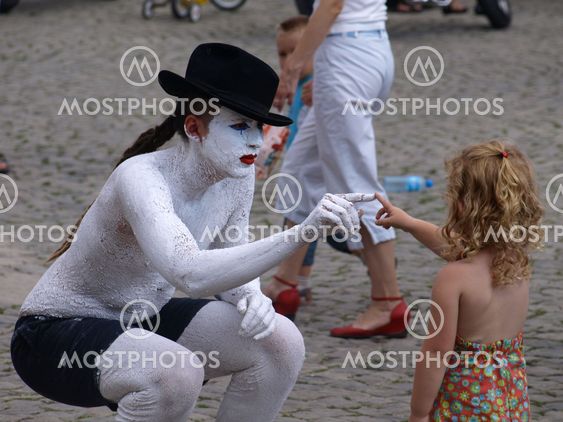 Street actor and young girl (tourist) on Old Market Place in Kazimierz Dolny, Poland