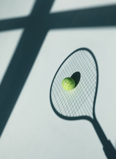 tennis racket and ball on the floor at room with daylight