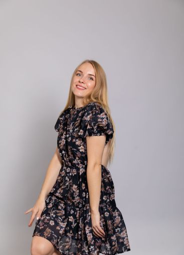 Beautiful blonde woman in summer dark dress on gray...