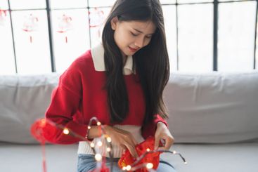 Asian Woman decorated house for Chinese New Year...