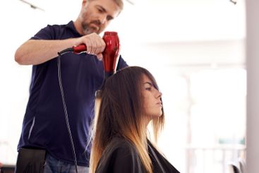 Beauty, woman and male hairstylist with hairdryer in...