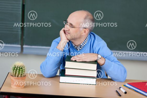 Teacher sitting thinking at his desk