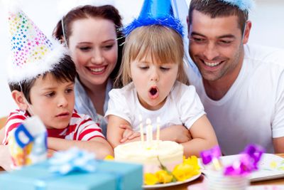 Little girl blowing out candles in her birthday