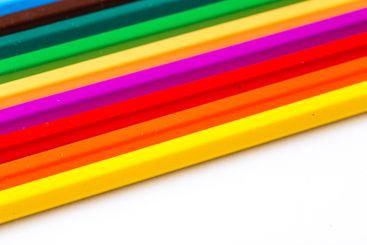 Vibrant colored pencils arranged in a line showcasing a...