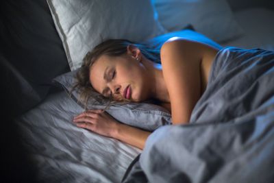 Beautiful young woman sleeping in bed (colour toned...