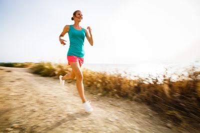 Young woman on her evening jog along the seacoast (motion...