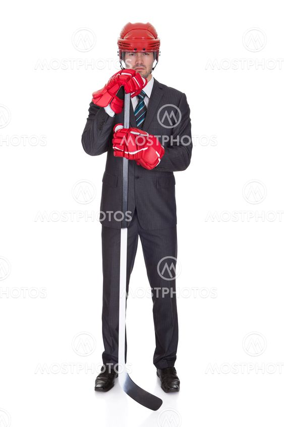 Competitive businessman wearing hockey equipment