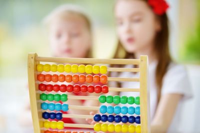 Cute little girl playing with abacus at home. Smart child...