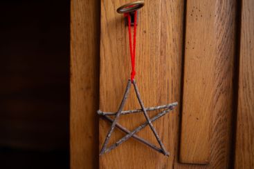 Five pointed star made from twigs, tied at points, red...
