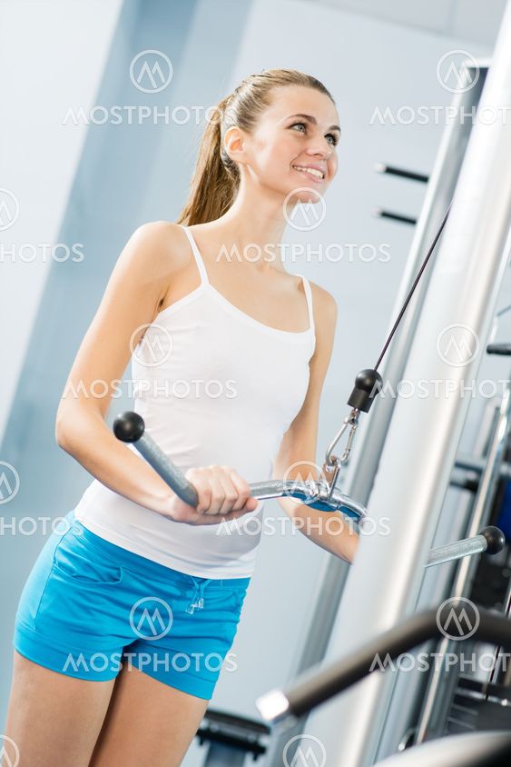 young woman doing body-building in the Gym