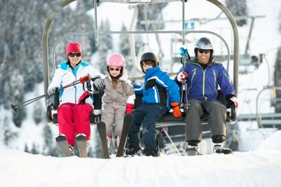 Family Getting Off chair Lift On Ski Holiday In Mountains