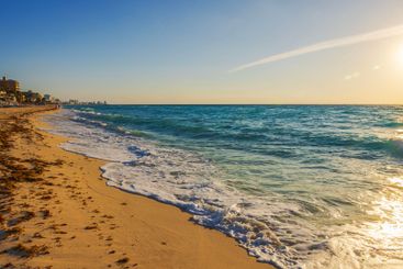 Golden evening sunlight reflects on gentle Caribbean waves