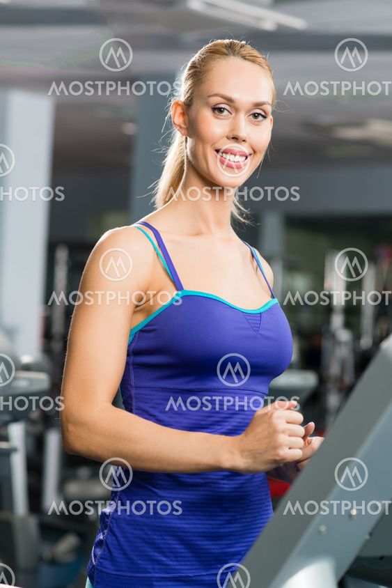 attractive young woman runs on a treadmill
