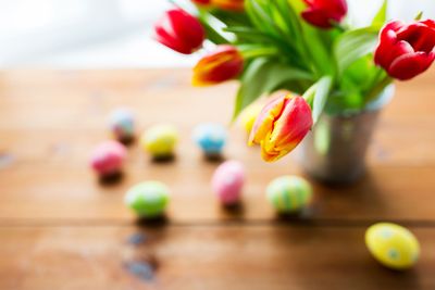 close up of easter eggs and flowers in bucket