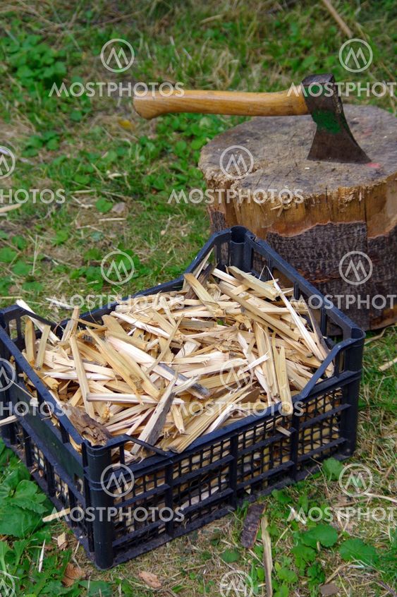 ax in stump with firewood in front it