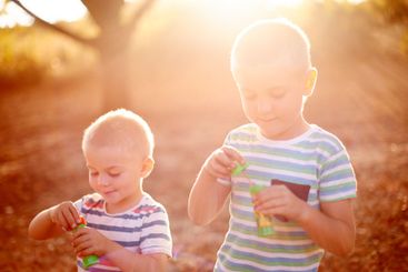 Sunshine, blowing bubbles and children in nature for...