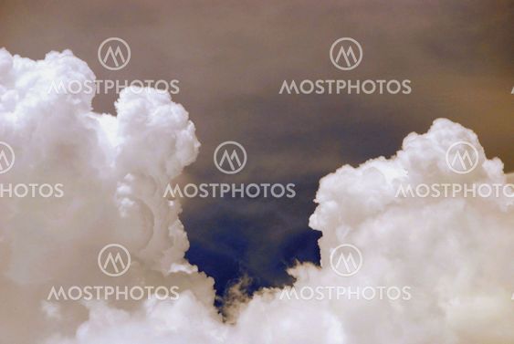 white puffy clouds rising up look cloes to see their faces