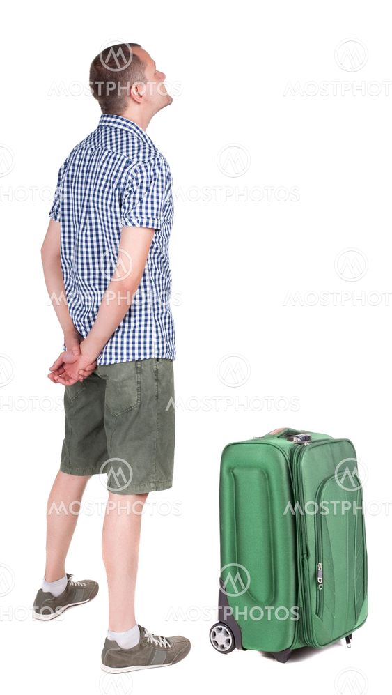 Back view of young man traveling with suitcas.