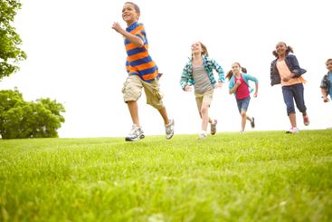 Fun, running and group of children on grass for outdoor...
