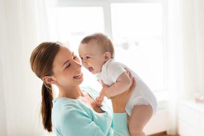 happy young mother with little baby at home
