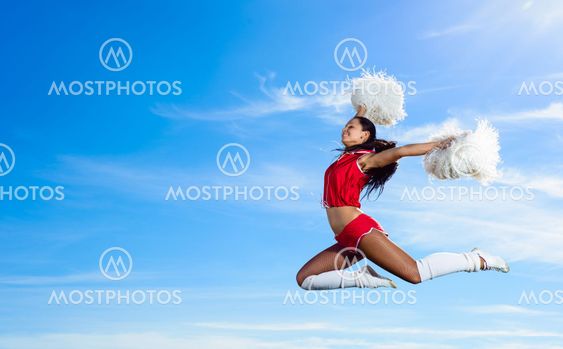 Young cheerleader in red costume jumping