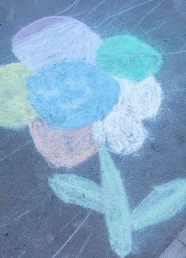 A detail of a child's colourful chalk picture on the...