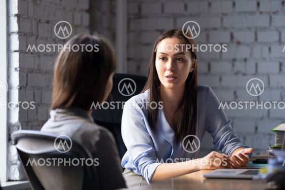 Serious professional female advisor consulting client at meeting