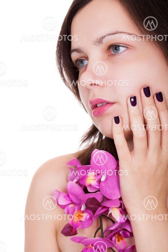 Woman with beautiful nails holding orchids
