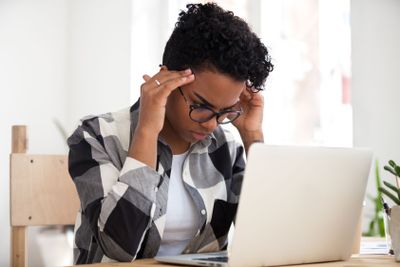 Stressed african woman concentrating doing difficult...