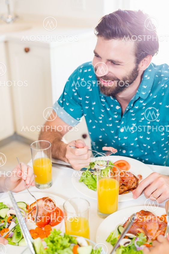 Young man sitting at dining table smiling