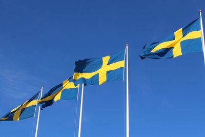 Svenska flaggor mot blå himmel