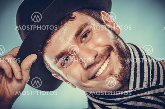 Happy man with half shaved face beard hair in hat.