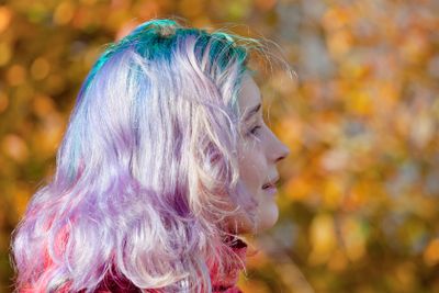 young woman half face with multicoloured streaks hair