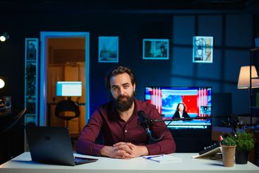 Close up of content creator using mic in studio to do...