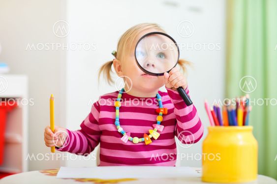 Toddler girl looking through magnifier