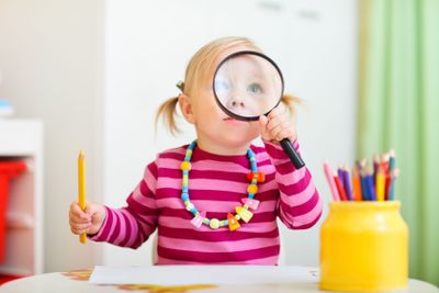 Toddler girl looking through magnifier