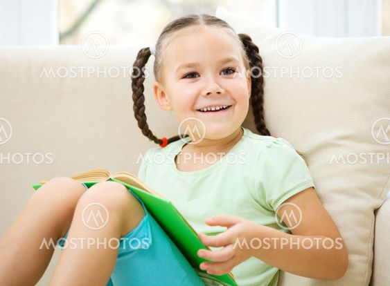 Little girl läser en bok